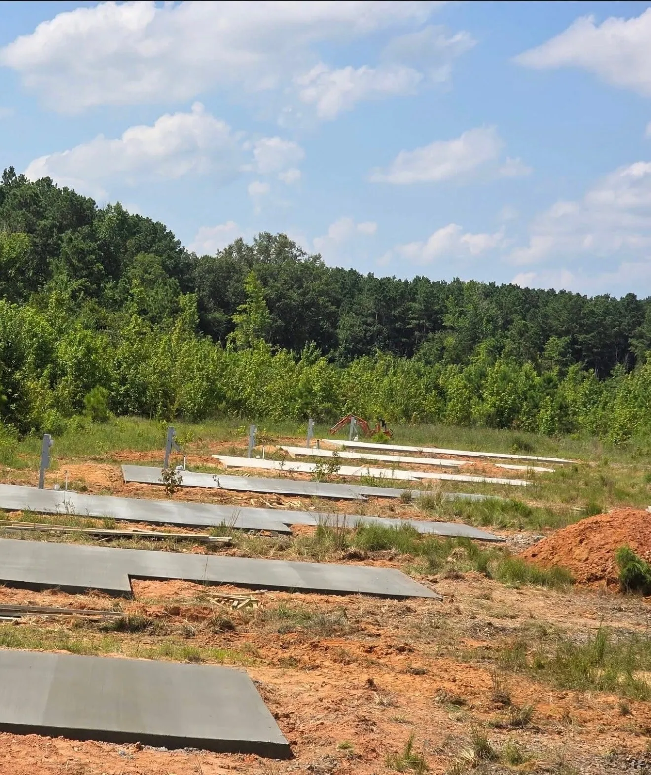 Several concrete pads poured on a wooded rural site