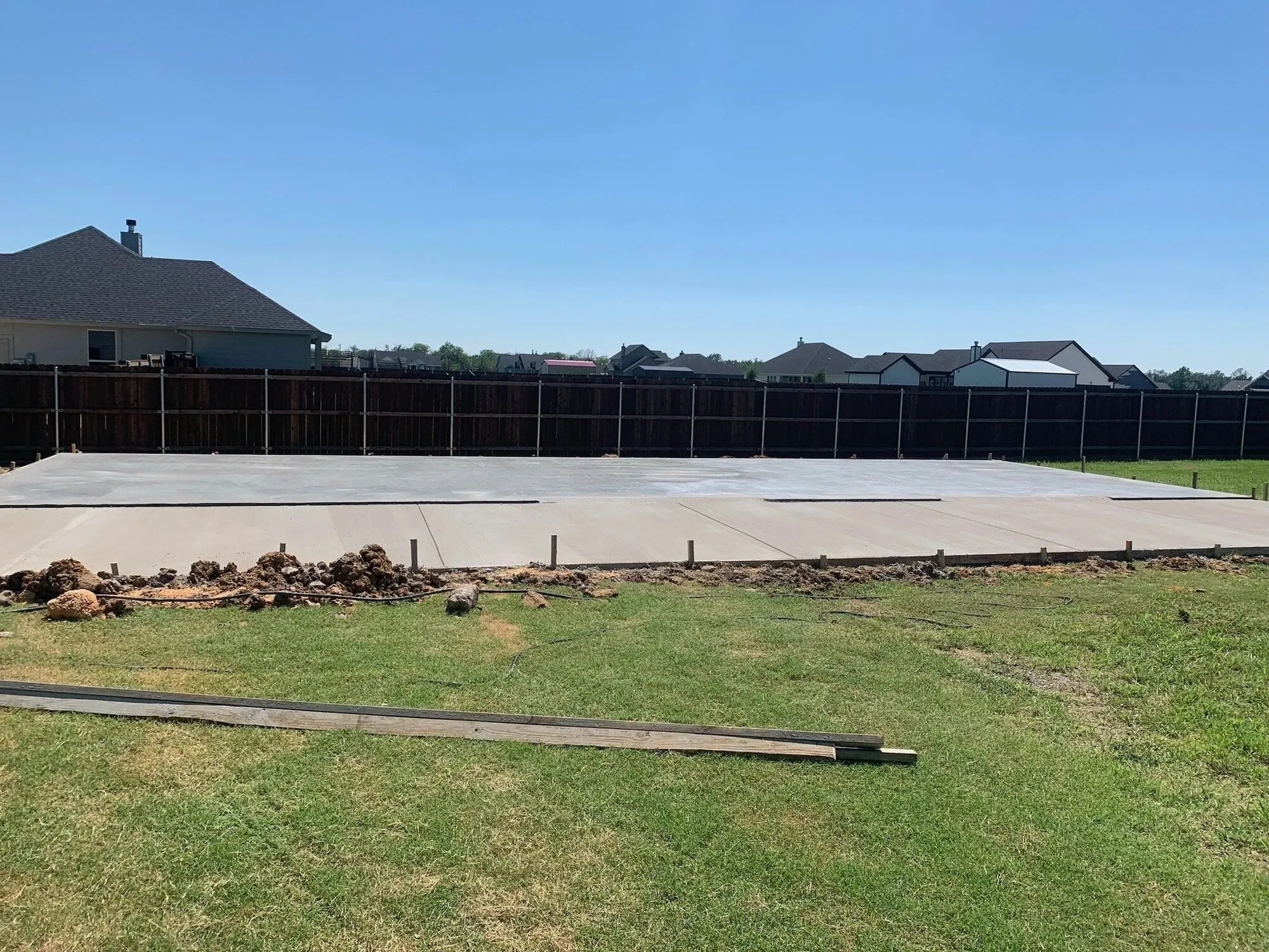Finished concrete slab in a back yard next to a home